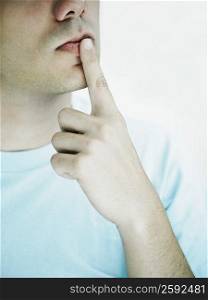 Close-up of a young man with his finger on his lips
