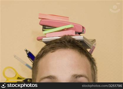 Close-up of a young man with stationery objects on his head
