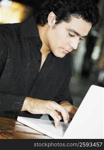 Close-up of a young man working on a laptop