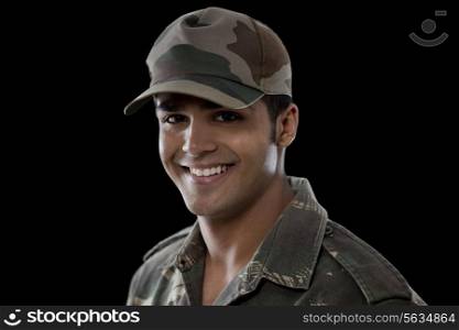 Close-up of a young soldier smiling over black background