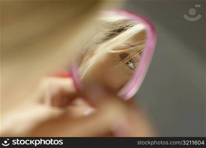 Close-up of a young woman&acute;s face in a vanity mirror
