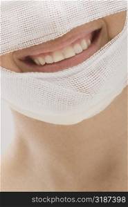 Close-up of a young woman&acute;s face wrapped with a bandage