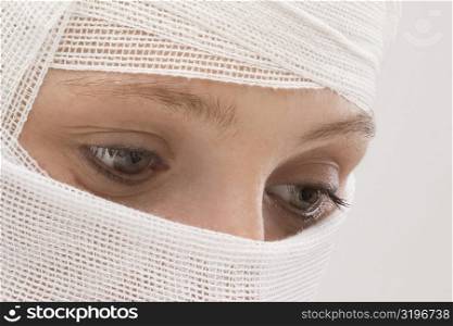 Close-up of a young woman&acute;s face wrapped with a bandage
