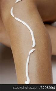 Close-up of a young woman&acute;s leg with hair removing cream
