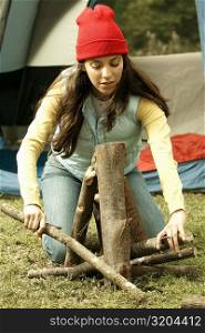 Close-up of a young woman adjusting firewood
