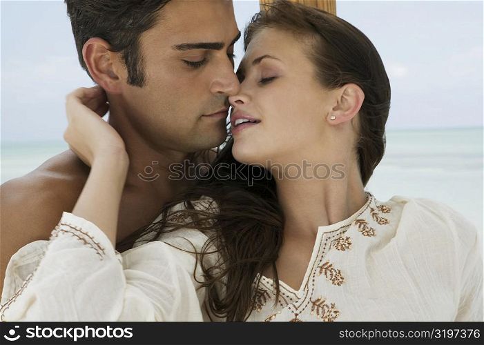 Close-up of a young woman and a mid adult man embracing each other