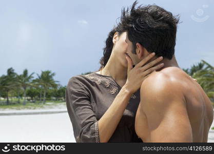 Close-up of a young woman and a mid adult man kissing each other