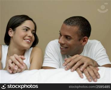 Close-up of a young woman and a mid adult man looking at each other and smiling