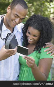 Close-up of a young woman and a mid adult man looking at a photograph