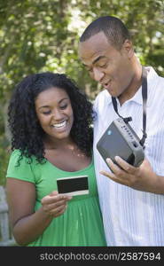 Close-up of a young woman and a mid adult man looking at a photograph