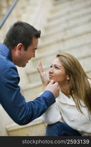 Close-up of a young woman and a mid adult man looking at each other