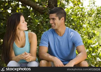 Close-up of a young woman and a mid adult man looking at each other