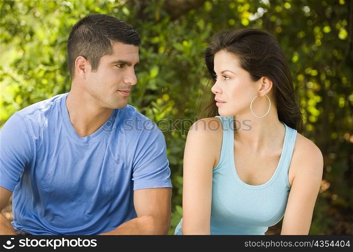 Close-up of a young woman and a mid adult man looking at each other