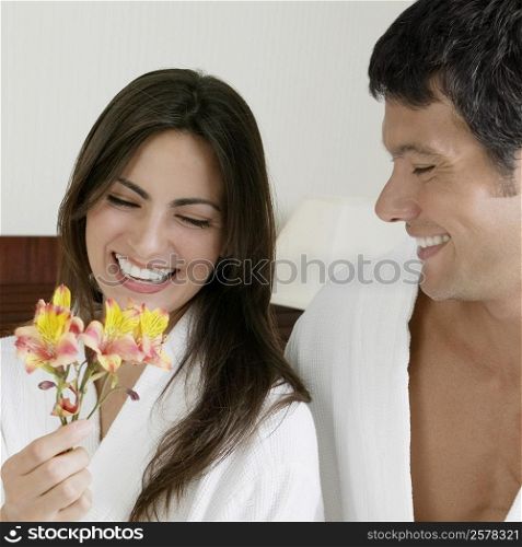 Close-up of a young woman and a mid adult man looking at flowers