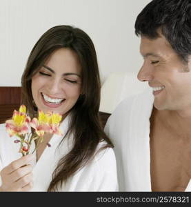 Close-up of a young woman and a mid adult man looking at flowers