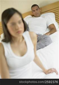 Close-up of a young woman and a mid adult man lying on the bed