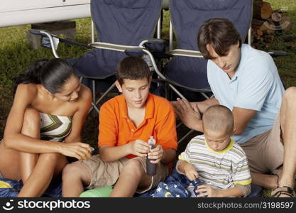 Close-up of a young woman and a mid adult man sitting with their two children