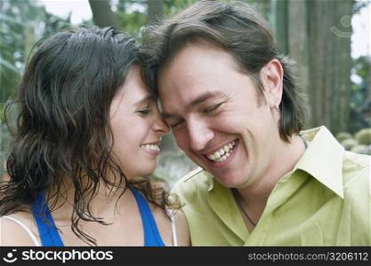 Close-up of a young woman and a mid adult man smiling in a park
