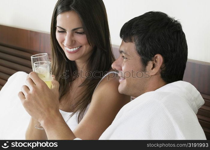 Close-up of a young woman and a mid adult man toasting with champagne flutes
