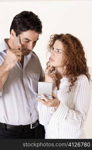 Close-up of a young woman and a mid adult man using a calculator