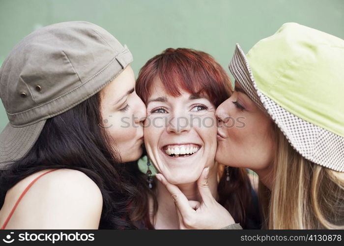 Close-up of a young woman and a mid adult woman kissing a young woman