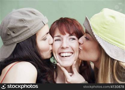 Close-up of a young woman and a mid adult woman kissing a young woman