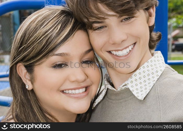 Close-up of a young woman and a teenage boy smiling
