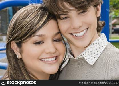 Close-up of a young woman and a teenage boy smiling