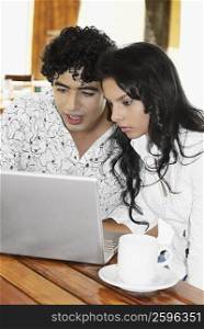 Close-up of a young woman and a teenage boy using a laptop