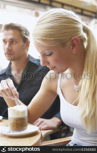 Close-up of a young woman and a young man seated at a table