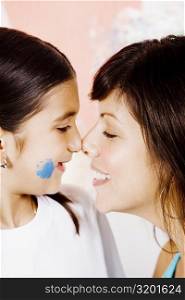 Close-up of a young woman and her daughter rubbing noses