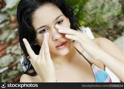 Close-up of a young woman applying suntan lotion