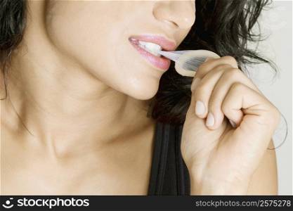 Close-up of a young woman biting a condom