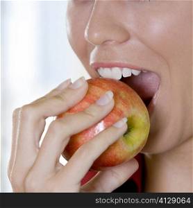 Close-up of a young woman biting an apple
