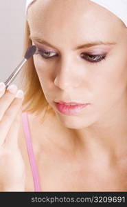 Close-up of a young woman brushing her eyebrow