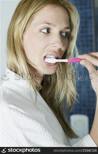 Close-up of a young woman brushing her teeth