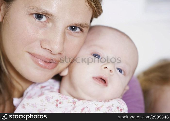 Close-up of a young woman carrying her baby girl
