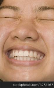 Close-up of a young woman clenching her teeth in pain
