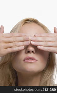 Close-up of a young woman covering her eyes with her hands