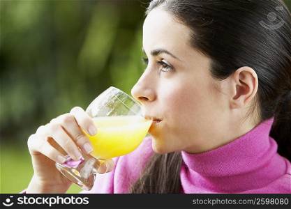 Close-up of a young woman drinking a glass of juice