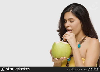 Close-up of a young woman drinking coconut milk