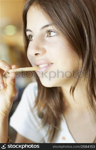 Close-up of a young woman eating French fries and smiling