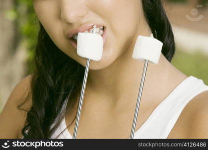 Close-up of a young woman eating marshmallows