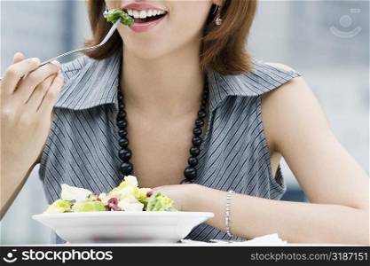 Close-up of a young woman eating salad