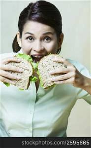 Close-up of a young woman eating sandwiches