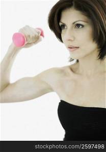 Close-up of a young woman exercising with a dumbbell