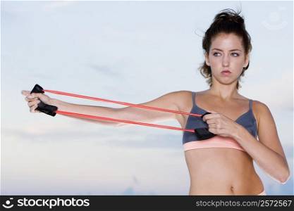 Close-up of a young woman exercising with a resistance band