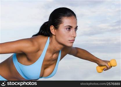 Close-up of a young woman exercising with dumbbells