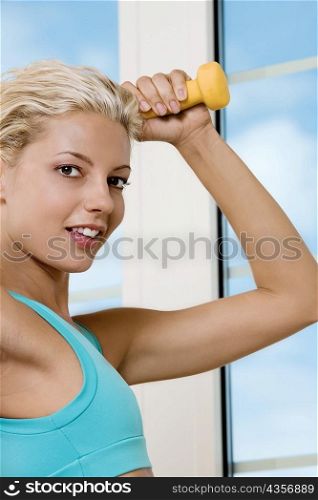 Close-up of a young woman exercising with dumbbells