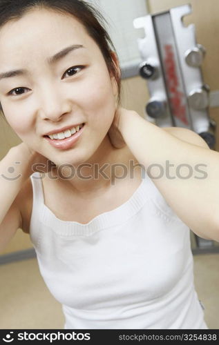 Close-up of a young woman exercising with her hands behind her head